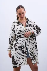 Camisa oversize blanca con estampado de manchas de vaca en color negro, de mangas largas y cuello camisero.