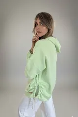Canguro oversize color verde menta, con capucha y bolsillo tipo canguro.