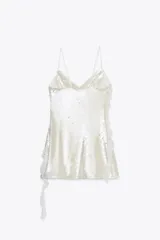 Vestido corto de fiesta color blanco, con lentejuelas y volantes.