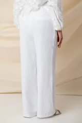 Pantalón blanco de tencel y lino, de pierna ancha y bolsillos laterales.