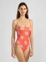 Traje de baño enterizo rojo con estampado de flores rosas, escote recto, breteles finos y espalda con lazo ajustable.
