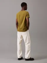 Remera verde oliva de corte slim, cuello redondo y manga corta. Tiene un pequeño parche con el logo de Calvin Klein en el pecho.