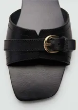Sandalias planas color marrón cuero, con punta cuadrada, diseño de tiras y hebilla decorativa.