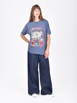 Remera de manga corta, corte holgado y efecto gastado (acid wash) en color gris oscuro. Estampado frontal con una rosa roja, estrellas y el texto "ROCK & ROLL" y "make some noise".