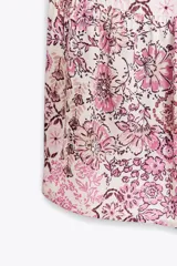 Vestido corto con estampado floral en tonos rosados, escote en pico y mangas abullonadas.