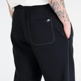 Pantalón de jogging negro de New Balance, con corte holgado y logo pequeño en la pierna izquierda.