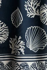 Short de tiro alto con estampado de motivos marinos en tonos azul y blanco. Presenta cintura elástica con cordón ajustable y bolsillos laterales.