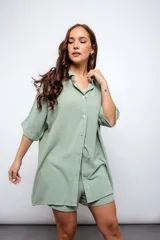 Camisa larga color beige con botones y cuello.