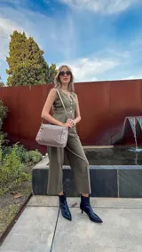 Bandolera de diseño moderno, color beige rosado, con correa regulable y bolsillo frontal con cierre.