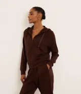 Campera deportiva marrón de modal, con capucha ajustable con cordón, cierre frontal con cremallera y bolsillos laterales.