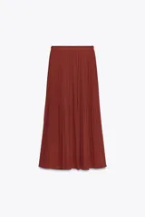 Falda midi color ladrillo, de tiro alto, con plisado fino y estampado de pequeños lunares. Incluye cinturón fino del mismo tejido y forro interior.
