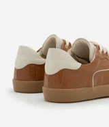 Championes chuteira color marrón con textura crocco, cordones blancos, suela color caramelo y detalles en blanco en los laterales y el talón.