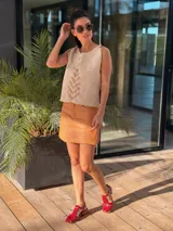 Minifalda de cuero color marrón claro, con diseño de paneles y corte recto.