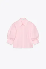 Camisa rosada de popelina de algodón, con cuello clásico, manga corta abullonada y cierre frontal con botones.