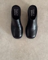 Zuecos negros de cuero con plataforma y taco ancho.