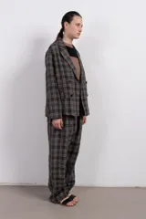 Pantalón cuadrillé de tiro bajo y silueta amplia, con cintura elástica, bolsillo trasero y calce levemente más ajustado en los tobillos.