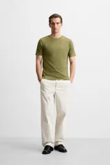 Camiseta slim fit de cuello redondo y manga corta, confeccionada en tejido de algodón con elasticidad.