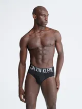 Pack de tres slips negros Calvin Klein de corte clásico, con cintura elástica con el logo de la marca en blanco y rojo.
