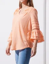 Blusa color celeste con escote en V, mangas largas acampanadas con detalle de crochet y frunces en los hombros.