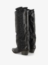 Bota de caña alta color negro, con detalle de tramado en los laterales, punta fina y taco ancho bajo. Fabricada en cuero.