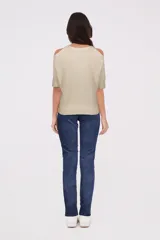 Sweater color crema de tejido de punto, con cuello redondo y hombros descubiertos.