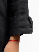 Camisa de manga larga, color negro, confeccionada en lino 100% con cuello camisero y botones frontales. Presenta un calce relajado.