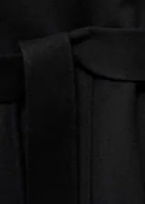 Abrigo negro largo con cuello de solapa, bolsillos laterales y cinturón desmontable.