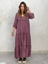 Vestido largo color morado, con escote en V, mangas largas y corte escalonado.
