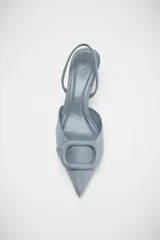 Zapato destalonado color marrón de tejido suave, con punta fina, tacón fino y tira trasera ajustable.
