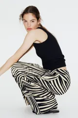 Pantalón de punto de corte holgado con piernas amplias, tiro alto, cintura elástica y cordón para ajustar. Estampado de hojas de palmera en blanco y negro.