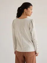 Remera blanca de algodón con escote redondo, mangas largas y pespuntes verticales a contratono.