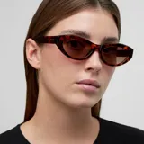 Lentes de sol con montura de acetato color carey (tortoise) y forma ovalada/cat eye. Las lentes son de color marrón polarizadas.