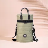 Matera estilo mochila color verde militar, confeccionada en nylon combinado con símil cuero negro. Tiene tapa con cierre metálico, bolsillo interno, asas cortas de mano y correa larga extensible.