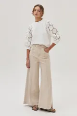 Blusa blanca de mangas 3/4 con bordado calado y cuello redondo con volados.