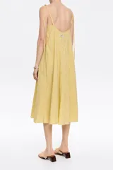 Vestido midi amarillo con rayas verticales finas, escote recto, tirantes finos con lazada y espalda con abertura redondeada.