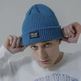 Gorro de lana blanco con etiqueta negra con el logo de la marca Pulau.