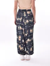 Pantalón babucha con estampado abstracto en tonos azul, beige y verde.