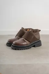 Zapatos de cuero negro con suela gruesa y diseño moderno.