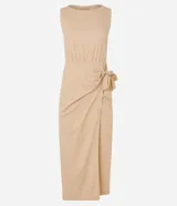 Vestido midi color beige, corte evasé, sin mangas, con lazo lateral y cierre trasero con cremallera.