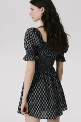 Vestido corto de crepé de algodón con estampado floral en blanco y negro, escote cuadrado con volantes, mangas cortas abullonadas con elástico en los puños, cuerpo ajustado con elástico y falda con vuelo.