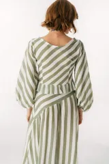 Blusa blanca de lino con escote en V, mangas largas abullonadas y frunce central.