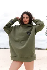 Canguro verde militar de algodón con capucha, corte oversize, puños y ruedo acanalados. Estampado pequeño de una flor en el pecho y la palabra 'cada.' en la manga.