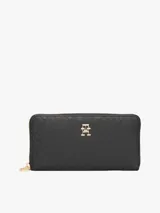 Billetera Tommy Hilfiger negra con diseño de monogramas TH en relieve y cierre de cremallera.