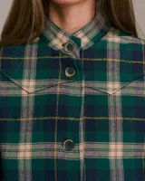 Chaqueta sin mangas acolchada con detalles western, con estampado a cuadros en tonos verdes, beige y azul marino. Presenta cuello mao, cierre frontal con botones y bolsillos de parche.