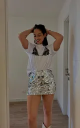 Minifalda plateada cubierta de lentejuelas, de tiro alto y corte ajustado.