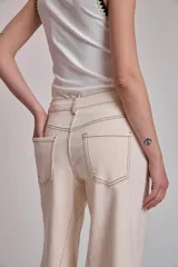 Pantalón de jean color crudo, corte palazzo con godets y costuras a contratono.