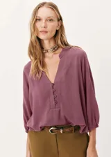 Blusa color marrón con escote en V y mangas 7/8 abullonadas.