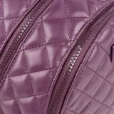 Mochila color lila de cuero sintético acolchado con diseño de rombos. Tiene acceso con cierre, dos compartimentos, un bolsillo interno con cierre y dos bolsillos internos abiertos. Las correas son regulables y los herrajes son plateados.