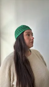 Gorro de crochet verde con diseño de red.