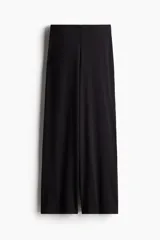Pantalón negro de punto suave, tiro alto, cintura elástica y piernas amplias.